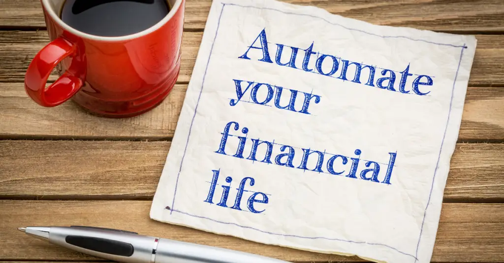 Coffee cup on desk with paper note that says, "Automate your financial life."